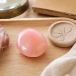 Galet d’opale rose opaque sur plateau en bois